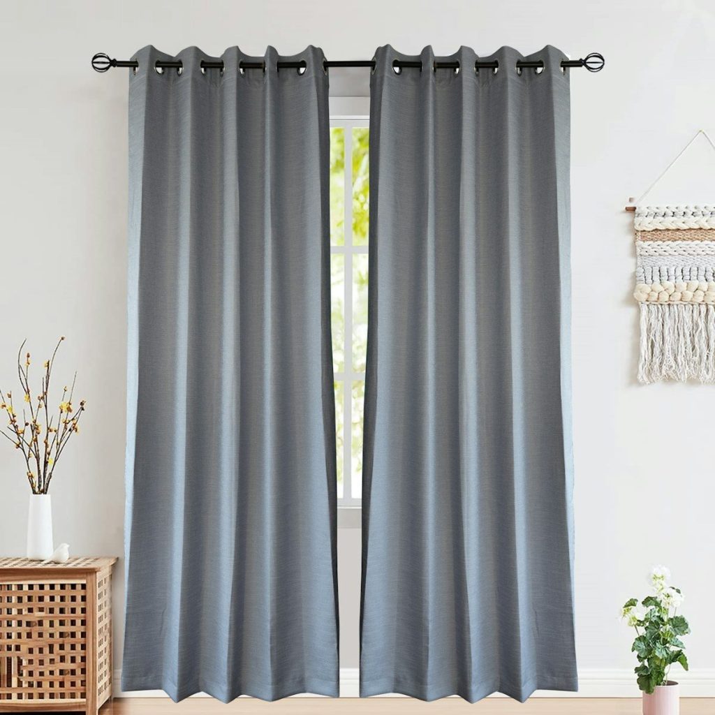 Two grey curtains hang covering a window.