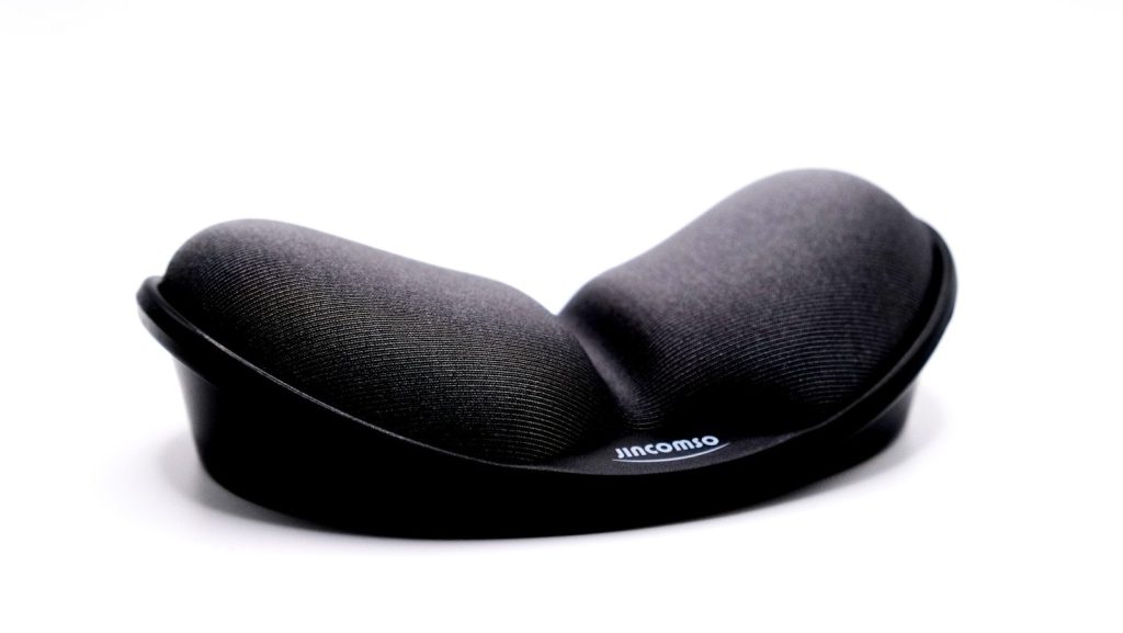 a close up of a black pillow on a white surface